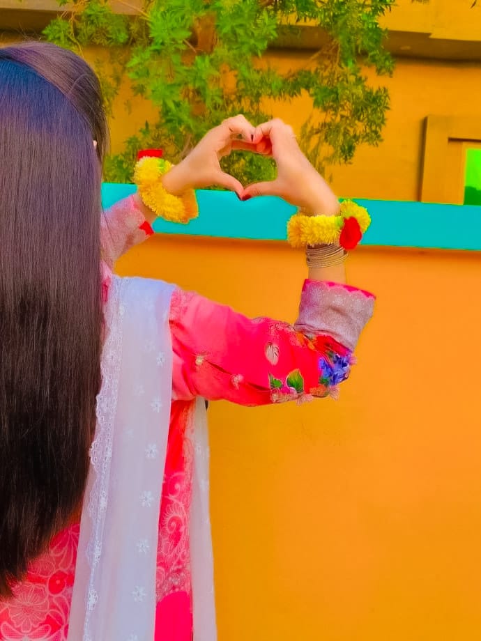 A girl has made a heart with her hands near the house and this very beautiful photography has been selected for DP pictures