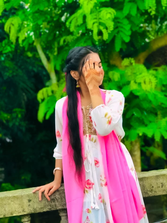 A girl standing in front of the trees with henna applied on her hands and wearing a pink dress is a very cute photography DP picture