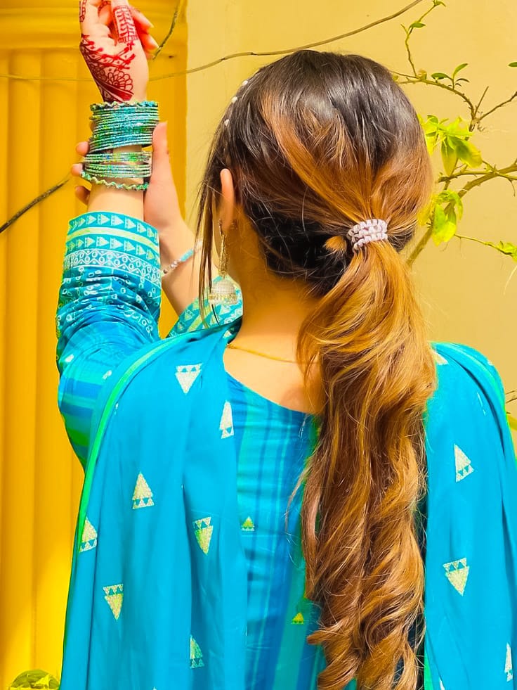 Cute photography of a woman wearing bangles in her hands, looking back and touching the bangles with both her hands