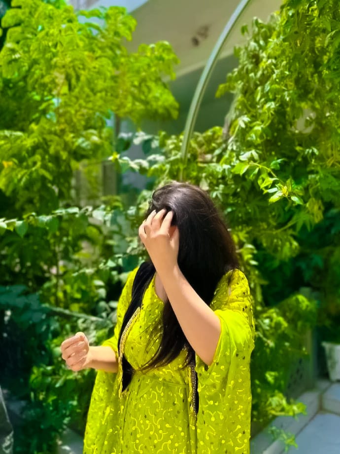 While walking, a girl covered her face with her hands and clicked a random photo in her courtyard.